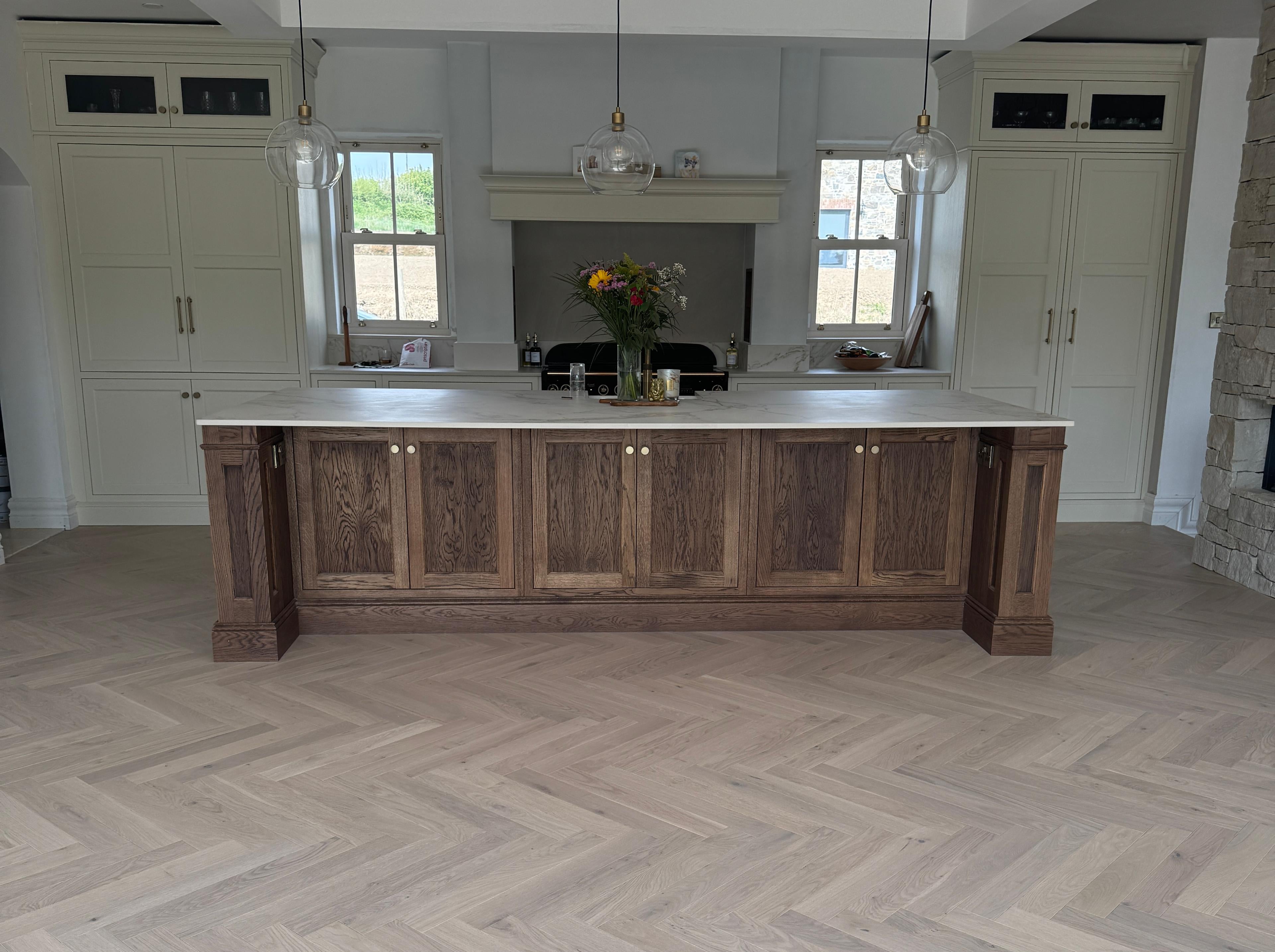 Modern kitchen with wooden island and herringbone floor pattern