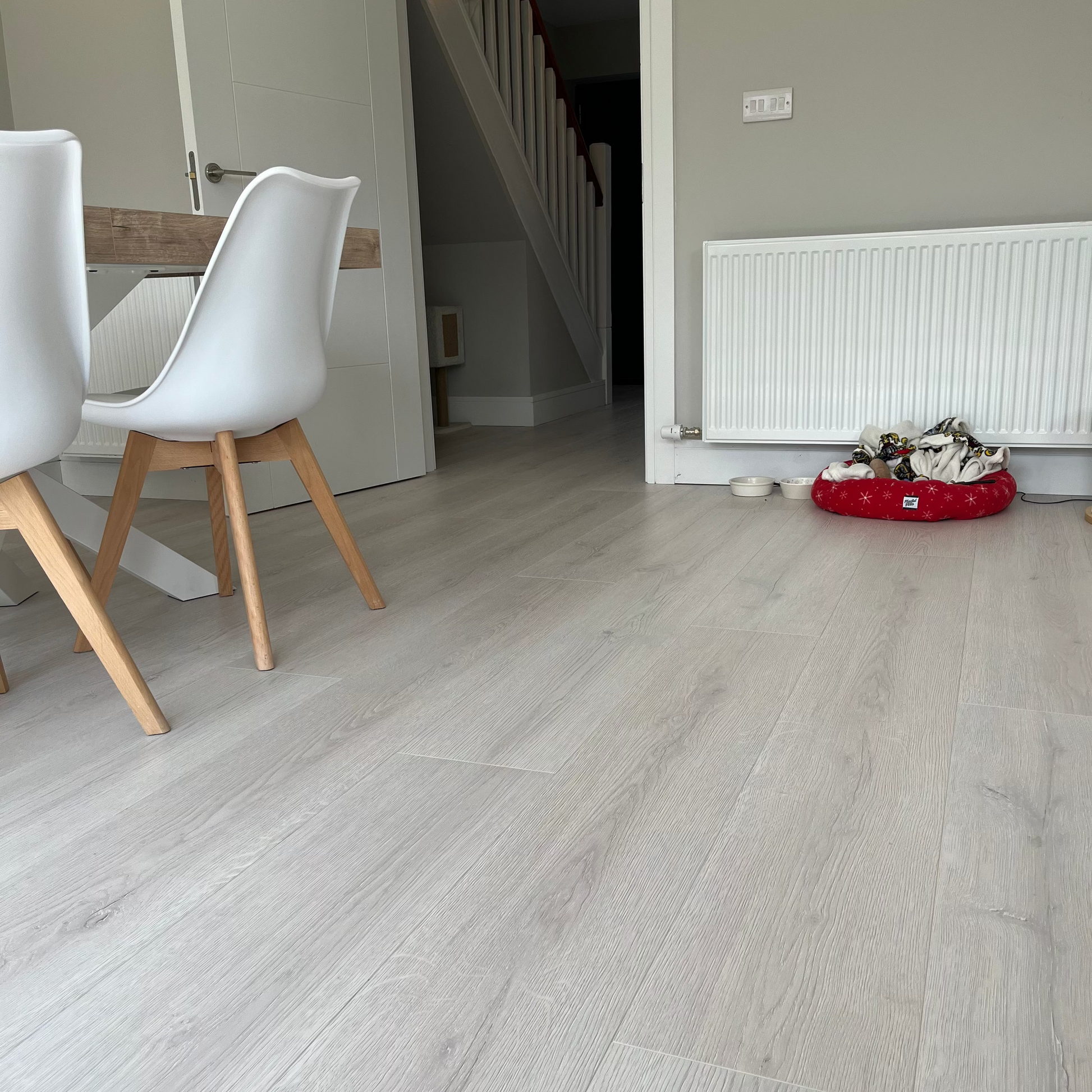 Modern interior with light gray flooring, white walls, and a staircase.